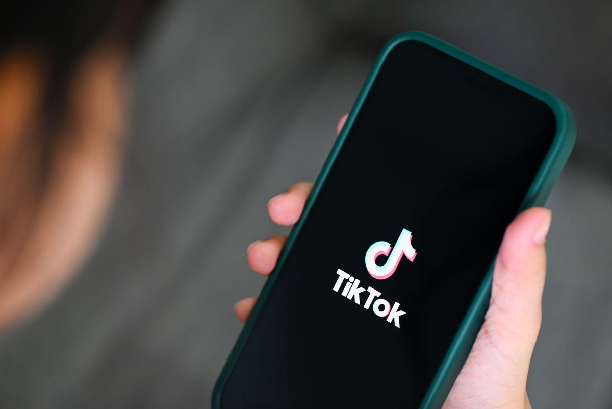 Closeup of hand holding smart phone with the logo of the video app TikTok on the screen.