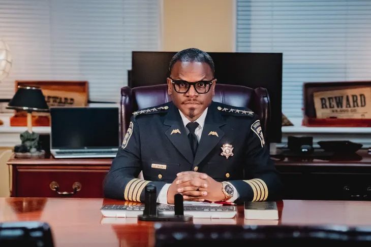 Interim sheriff Levon Allen sitting at desk in uniform.