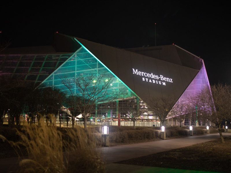 Mercedes-Benz Stadium lite up at night.